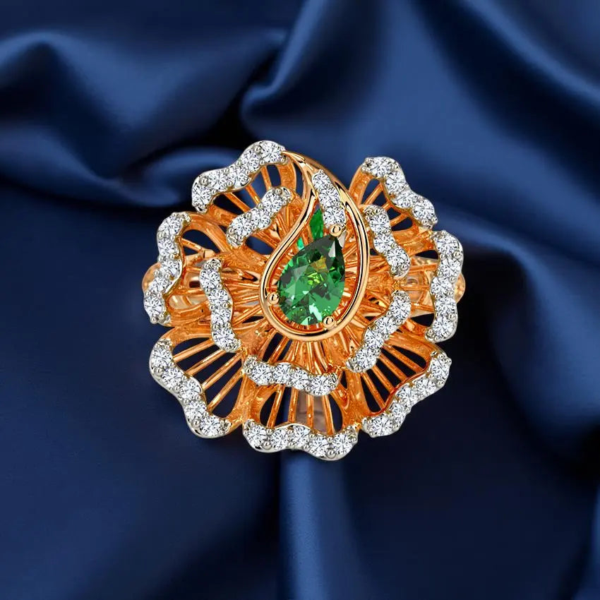 Ornate brooch with green gemstone and diamonds on a blue satin background