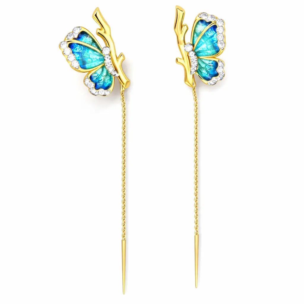 Butterfly-shaped earrings with blue wings and gold accents on a white background