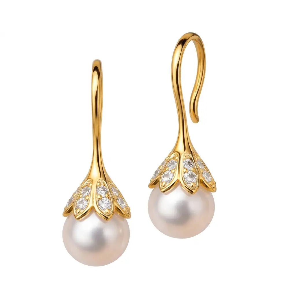 Gold earrings with pearl drops on a white background