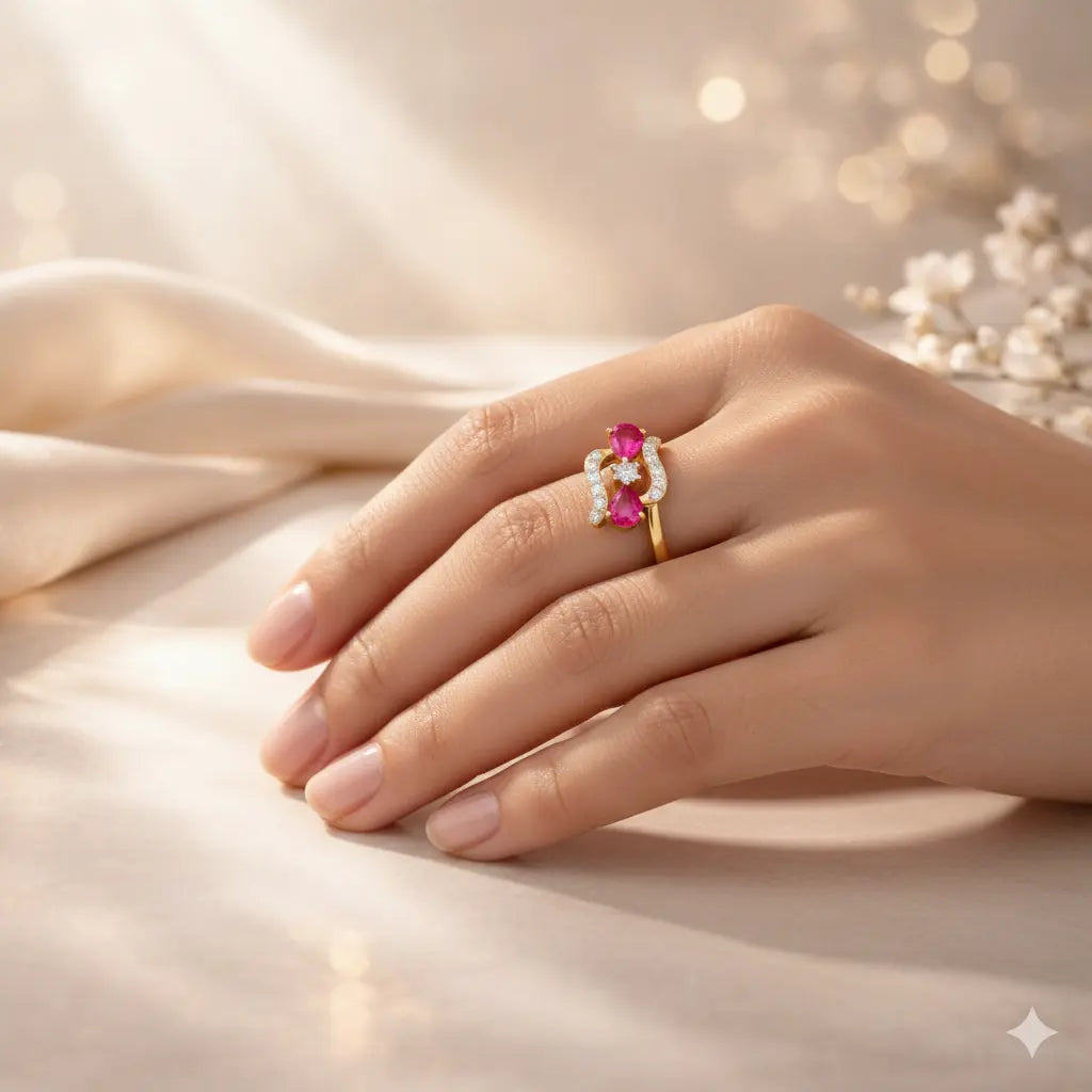 Hand wearing a gold ring with a pink gemstone on a soft fabric background