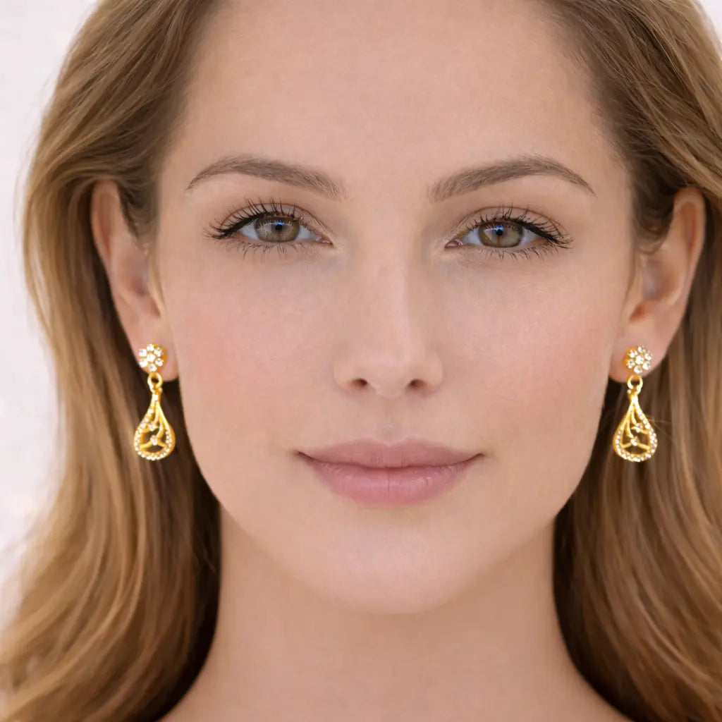 Close-up of a woman wearing gold earrings with a plain background