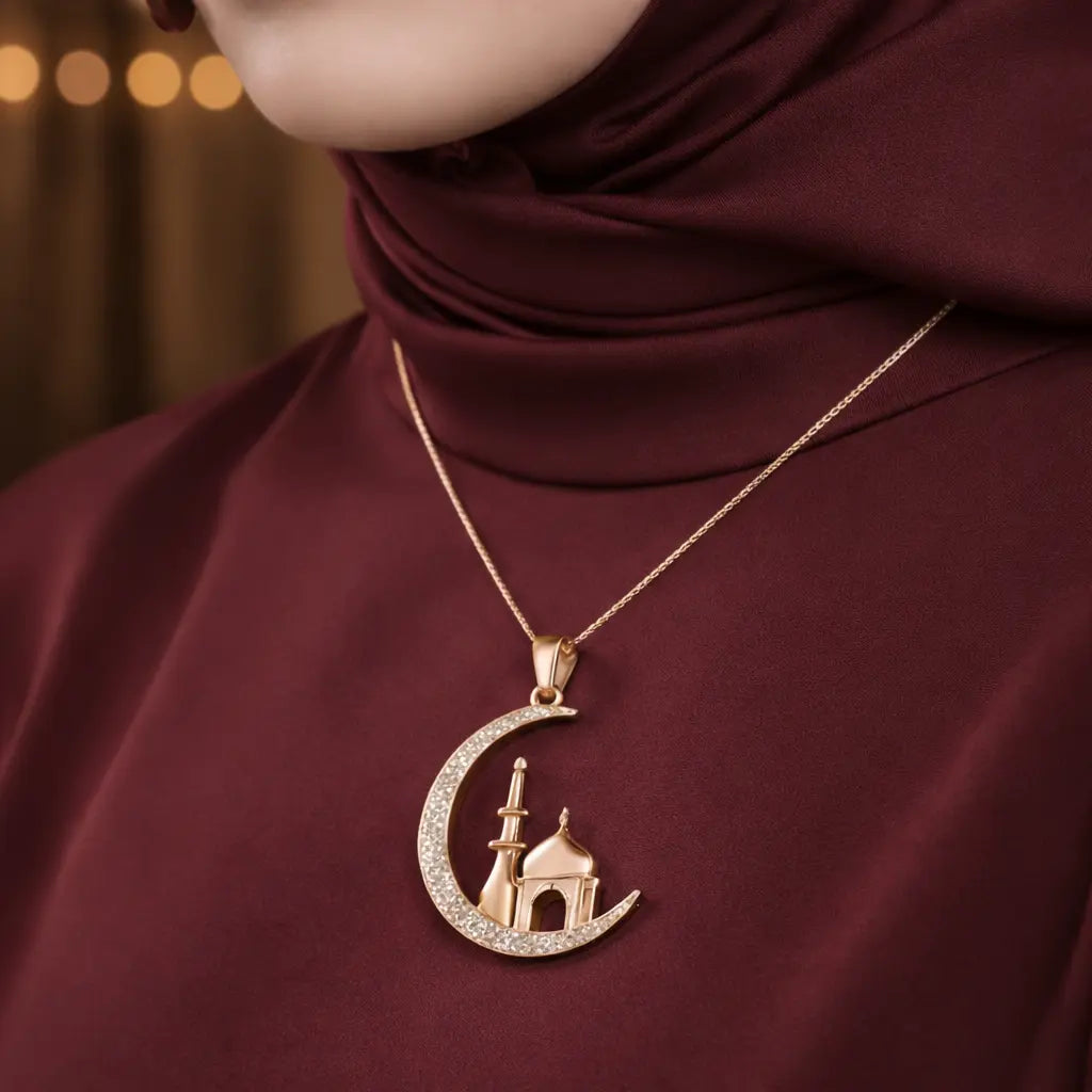 Rose gold necklace with crescent moon and mosque pendant on a maroon background