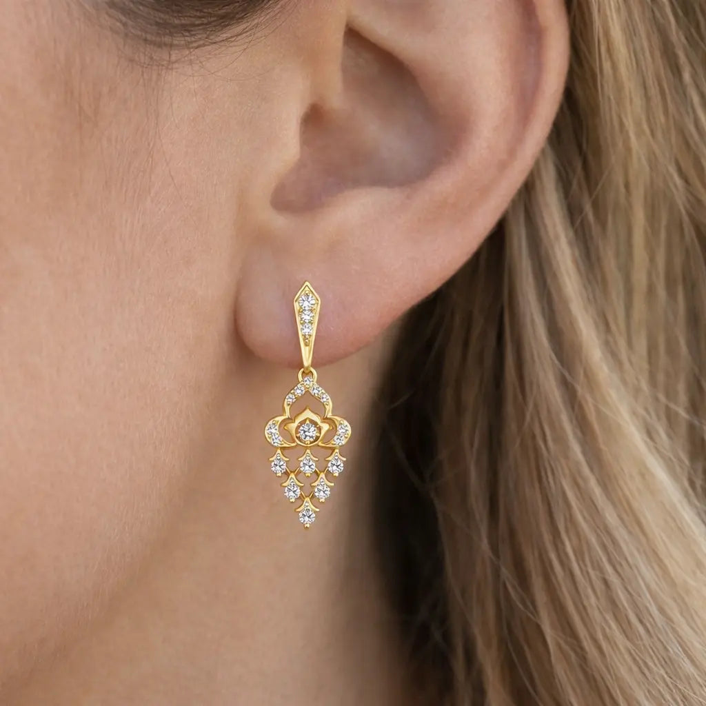 Gold earring with clear stones worn by a person