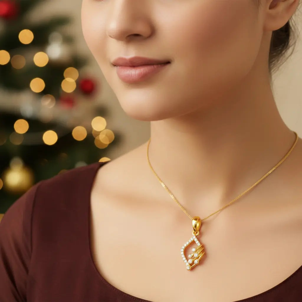 Woman wearing a gold necklace with a decorative pendant against a blurred festive background