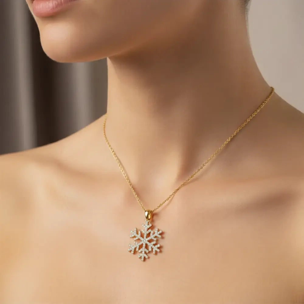 Gold necklace with a snowflake pendant on a neutral background
