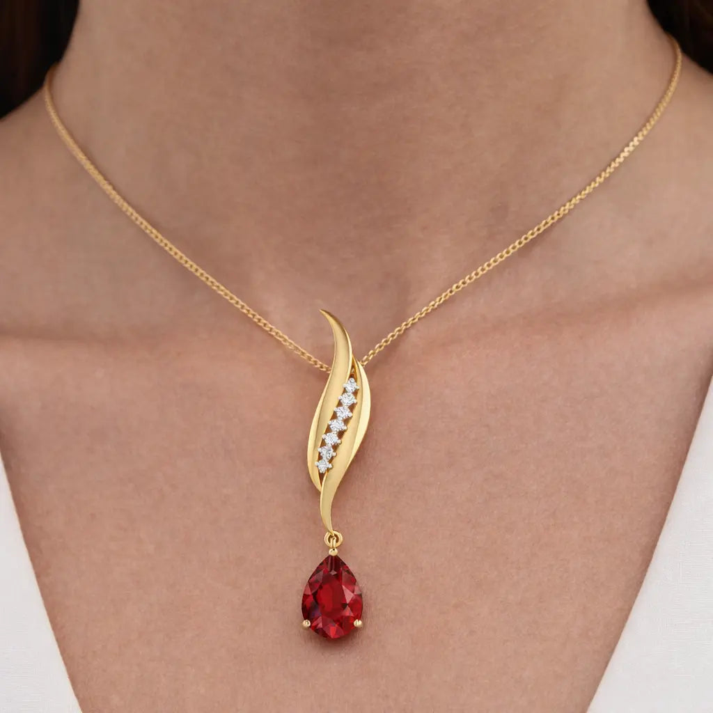 Gold necklace with a red gemstone pendant on a person's neck