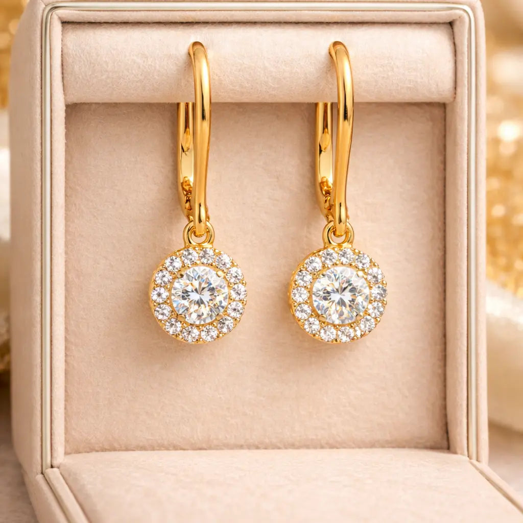 Gold earrings with clear gemstones in a jewelry box