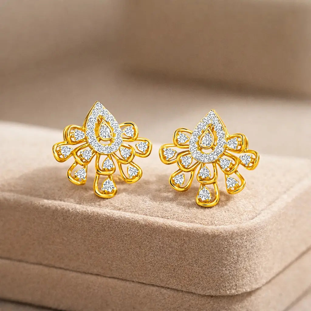 Gold earrings with diamond accents on a beige cushion