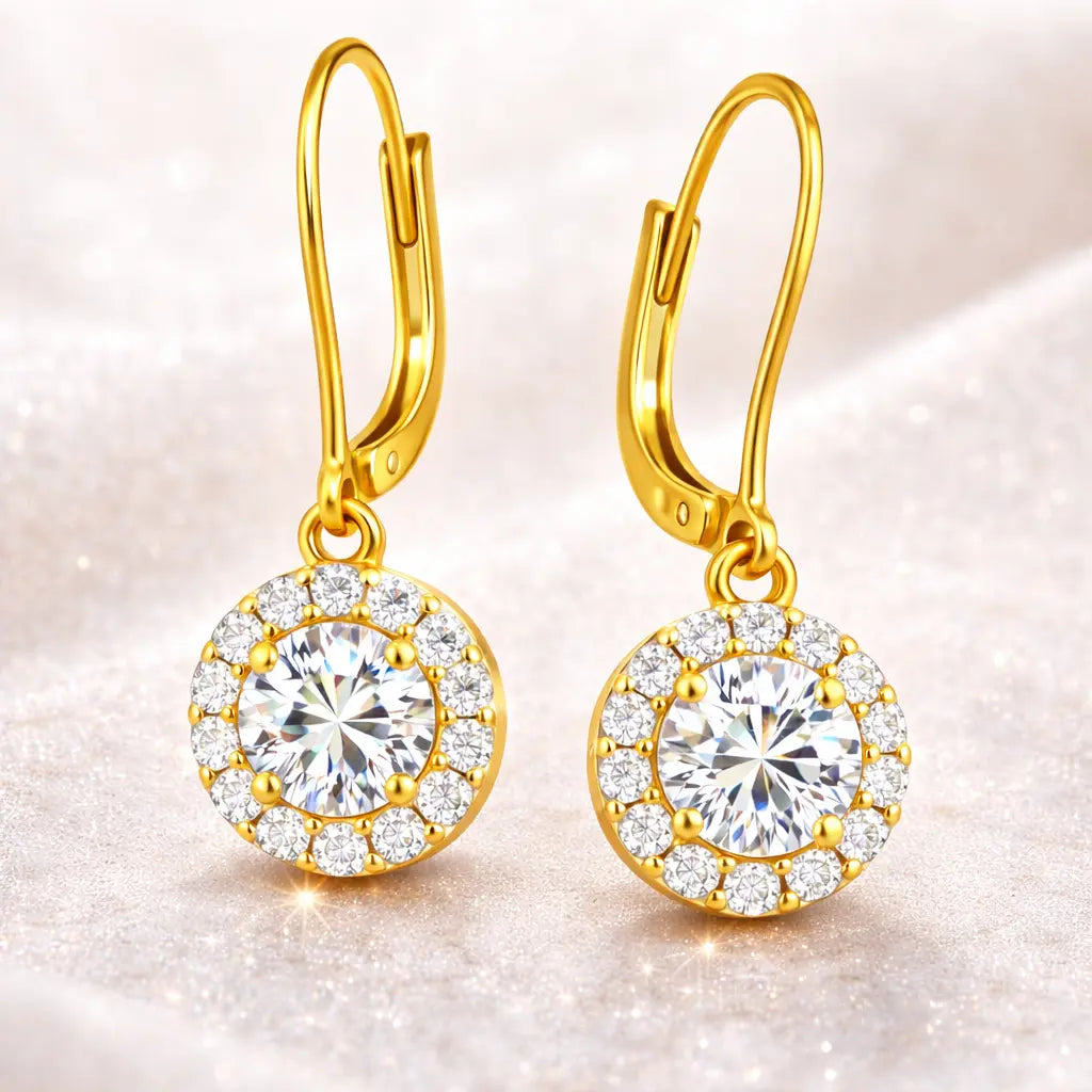 Gold earrings with large central gemstones on a soft background