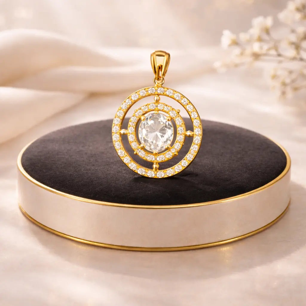 Gold pendant with a central gemstone on a black cushion against a beige background
