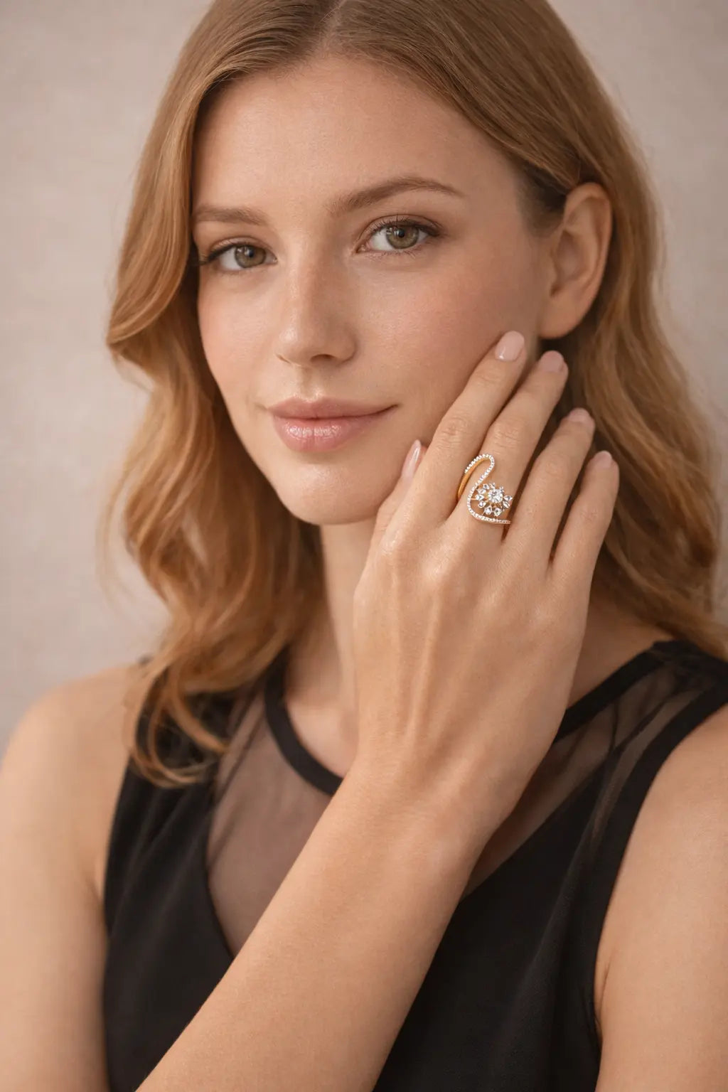 Woman wearing a gold ring with a diamond on her finger, against a neutral background