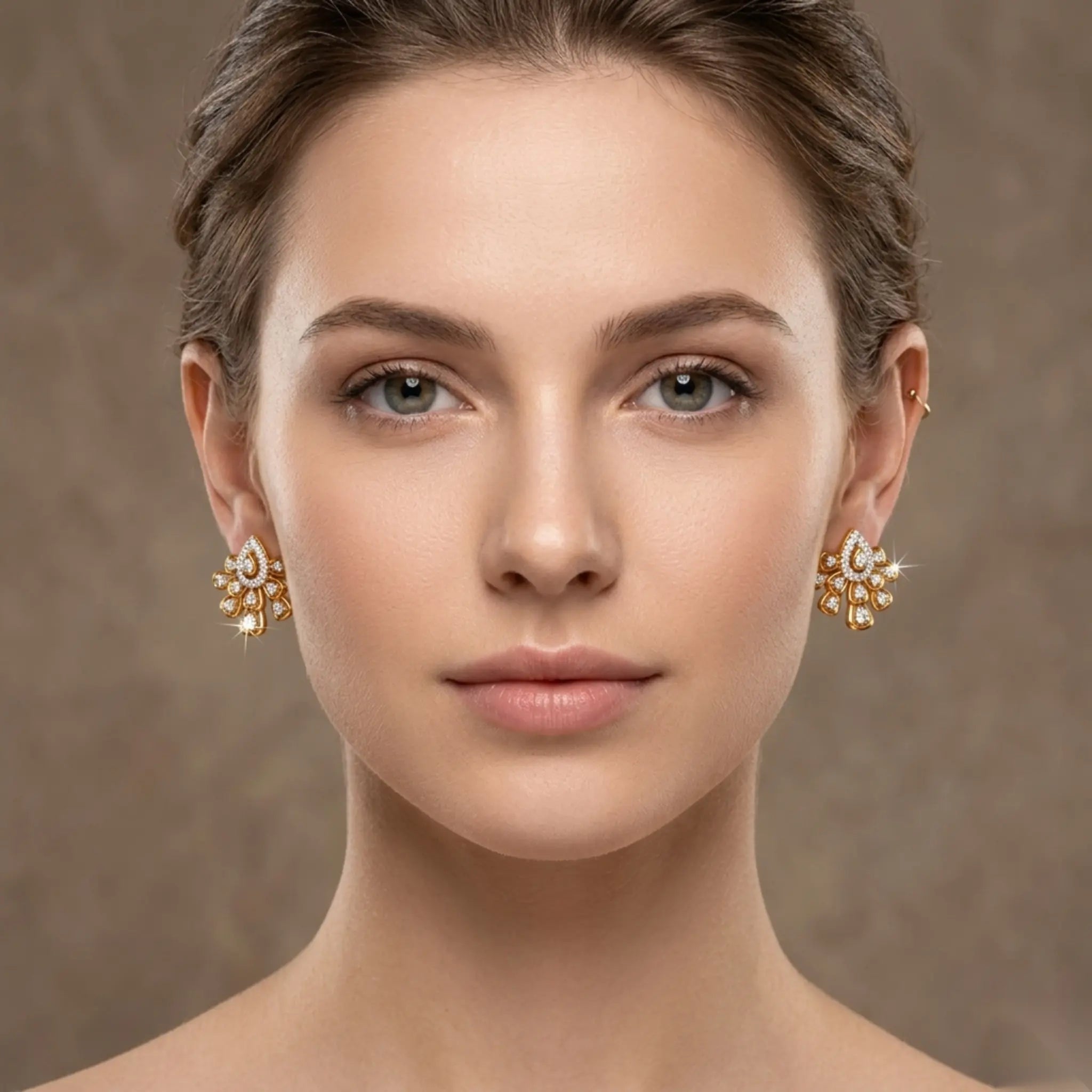 Woman wearing gold earrings against a neutral background