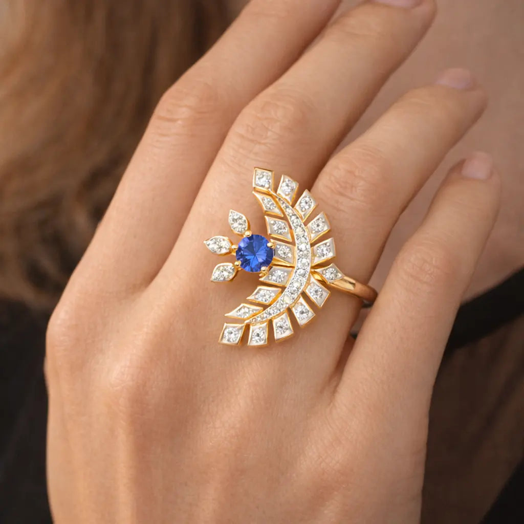 Gold ring with a blue gemstone on a person's finger