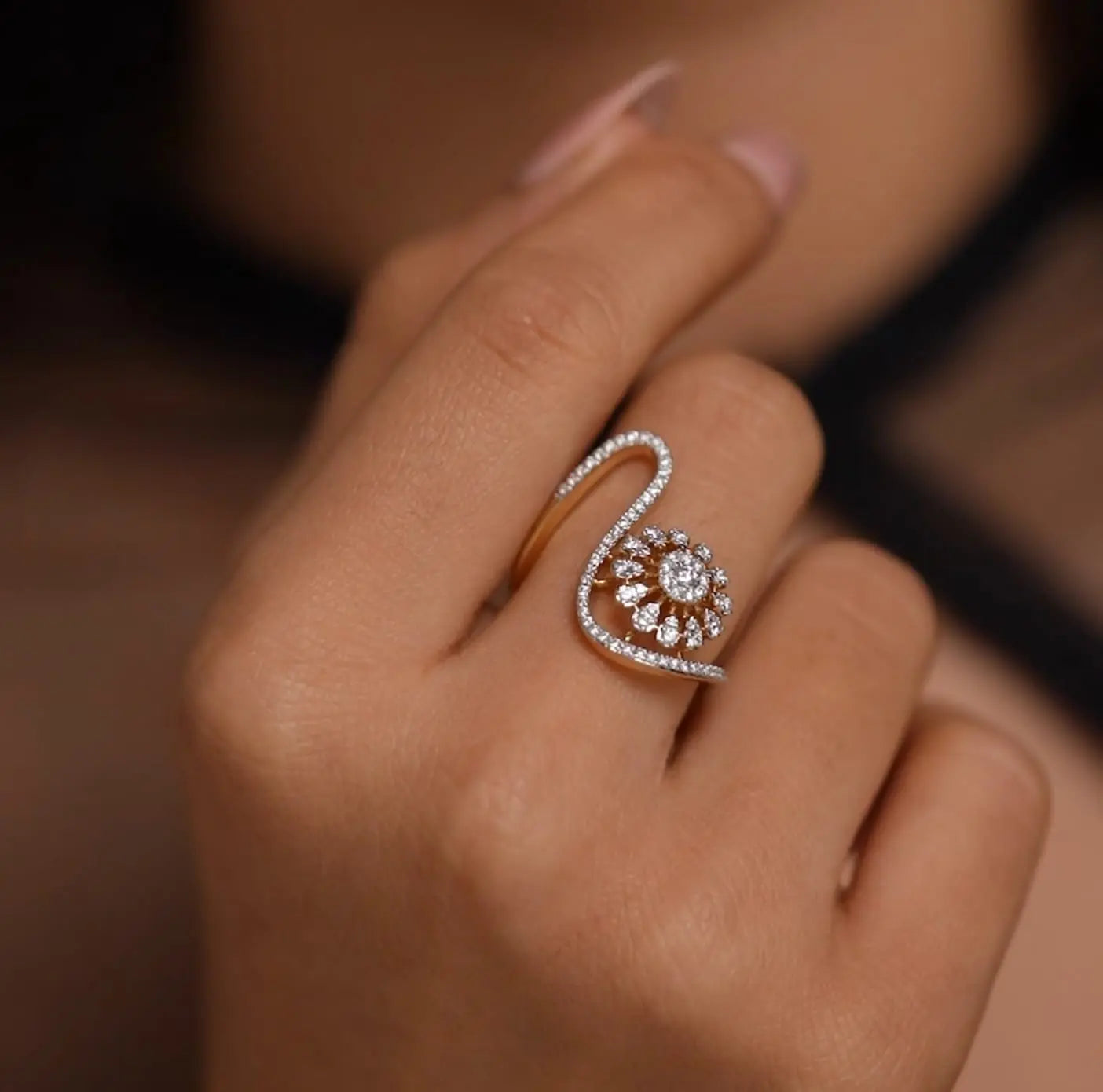 Close-up of a hand wearing a diamond ring with a blurred background