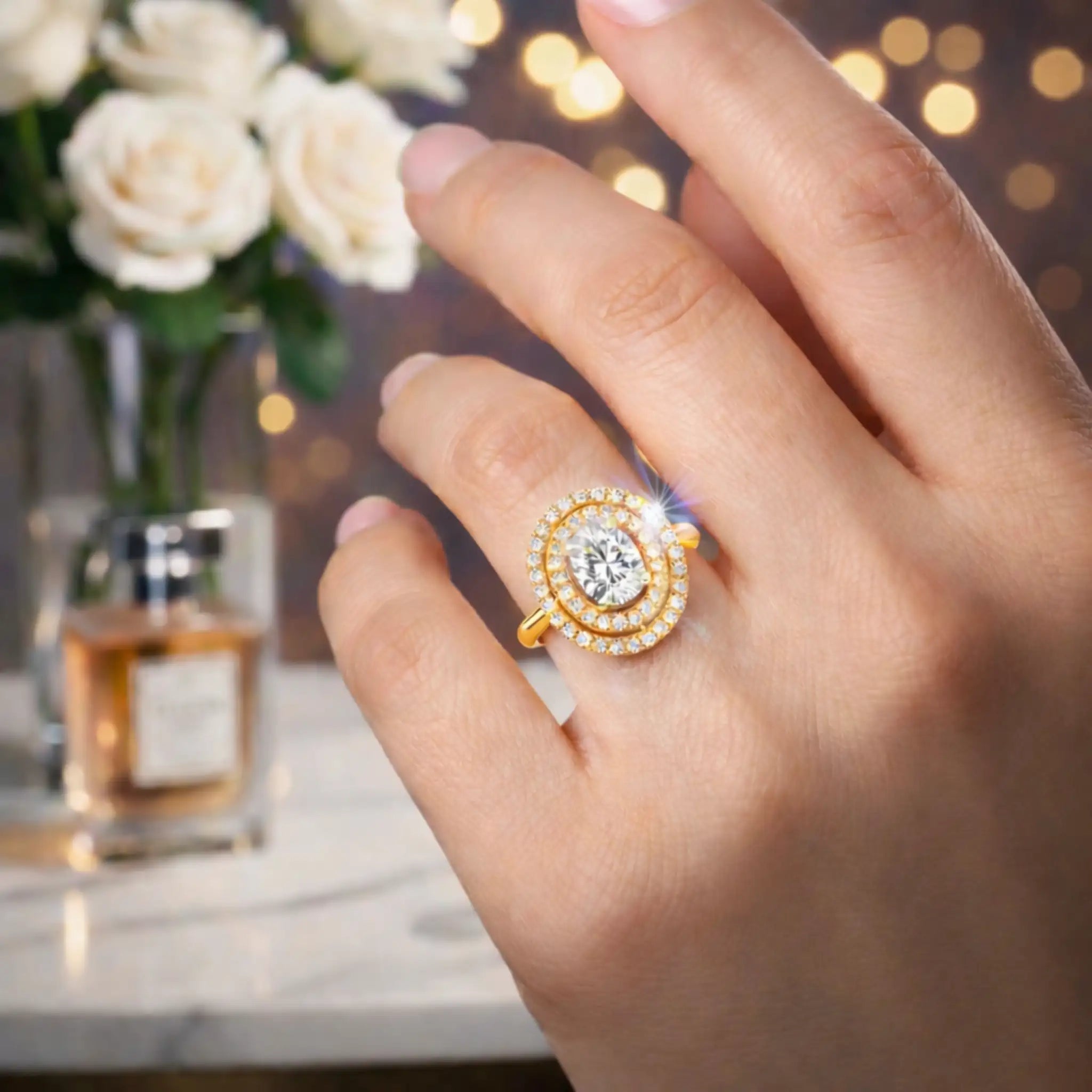 Gold ring with a diamond on a hand, with flowers and perfume bottle in the background
